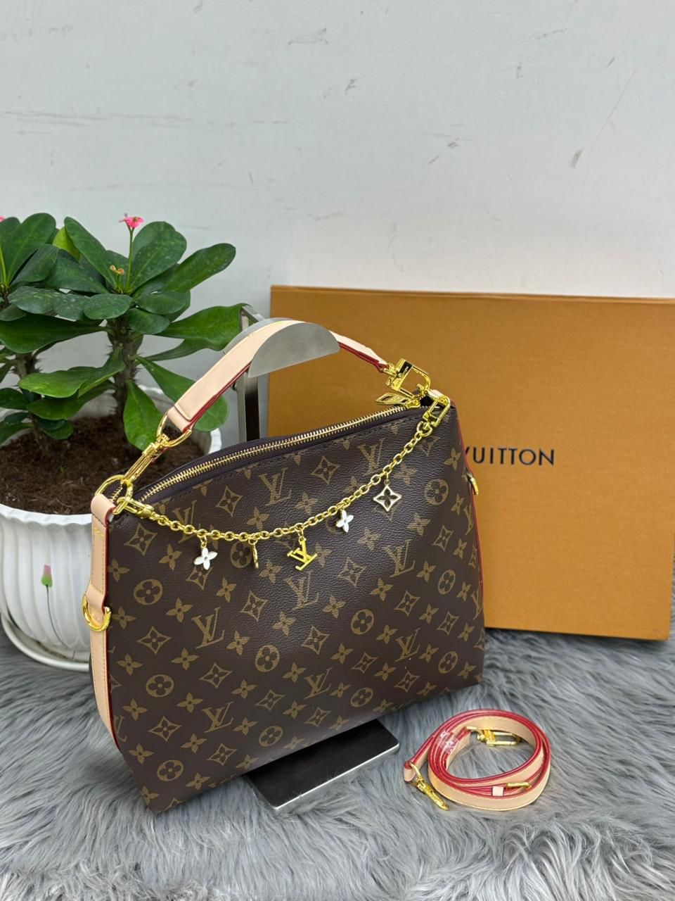 Louis Vuitton classic monogram hobo bag with decorative gold charm chain detail