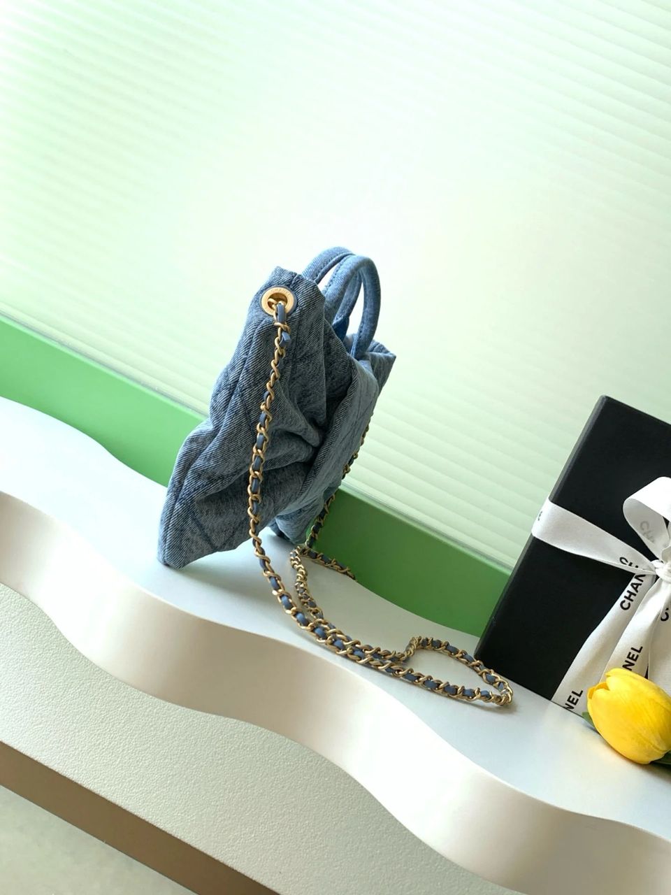 Side view of blue Chanel quilted handbag
