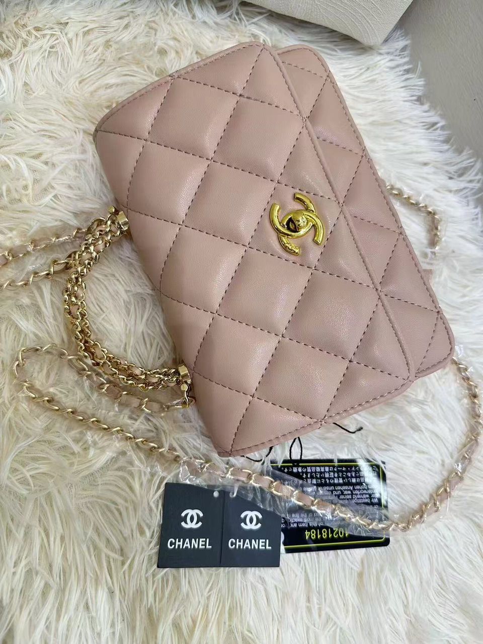 Soft rose pink Chanel quilted mini flap bag on luxury display