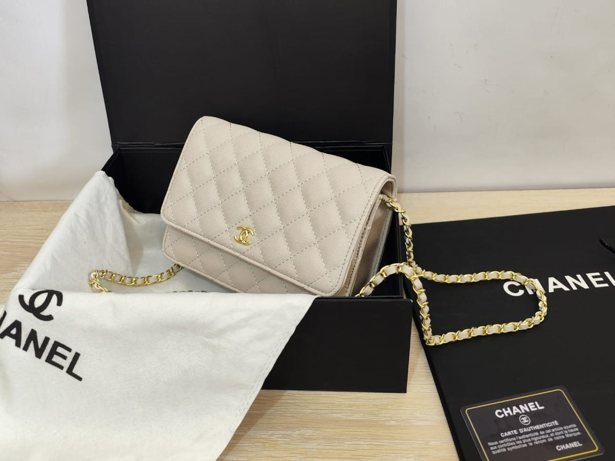 Angled view of white Chanel quilted chain bag