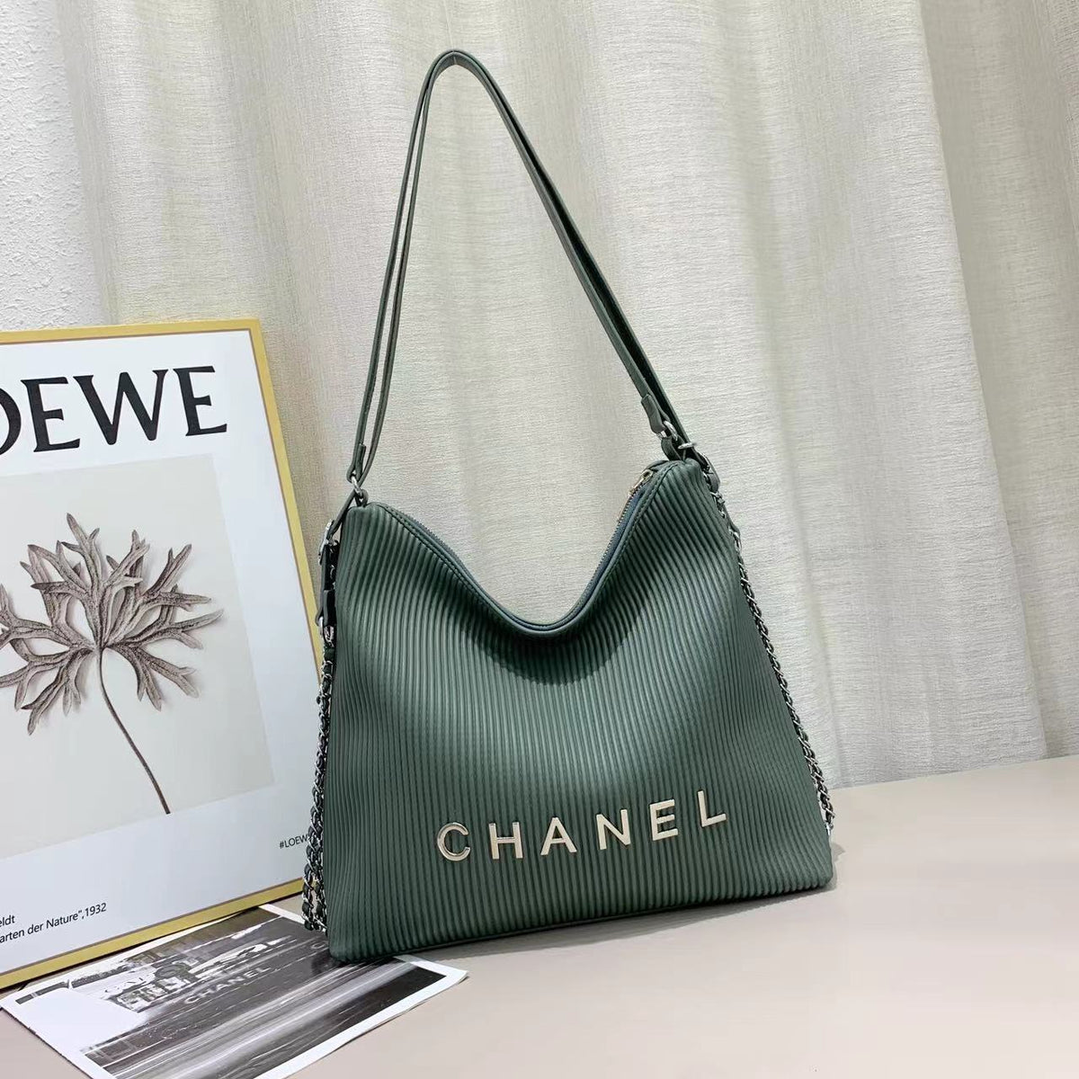 Chanel women's shoulder bag in green with curved design and logo detail