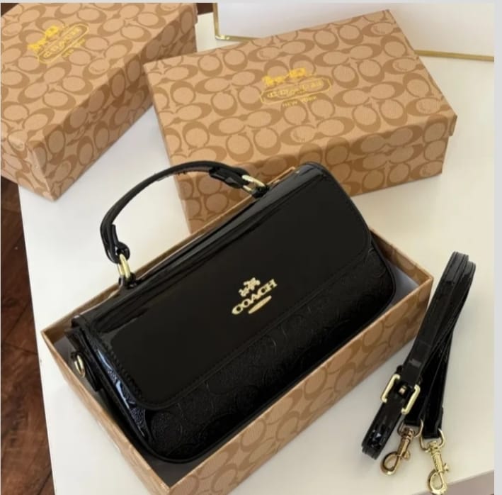Angled view of black Coach crossbody bag with strap