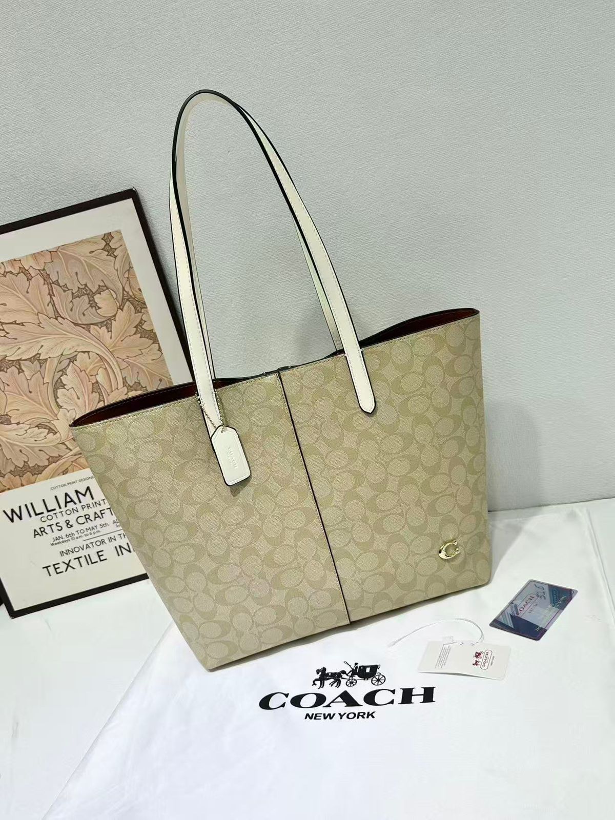 Cream Coach signature canvas tote bag with white leather shoulder handles
