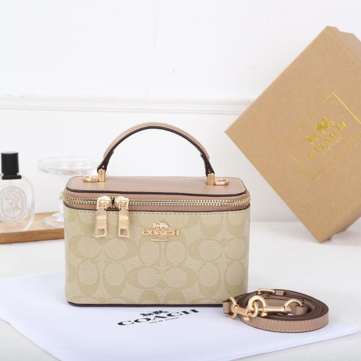 Cream and tan Coach signature mini vanity crossbody bag with strap