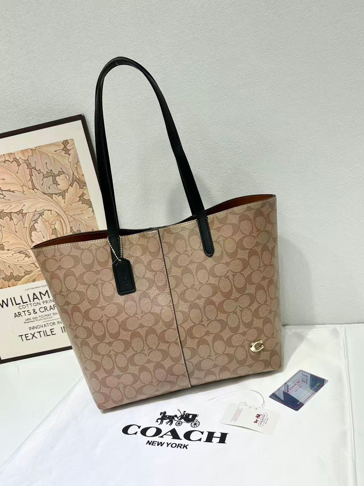 Tan brown Coach signature canvas tote bag with black shoulder handles