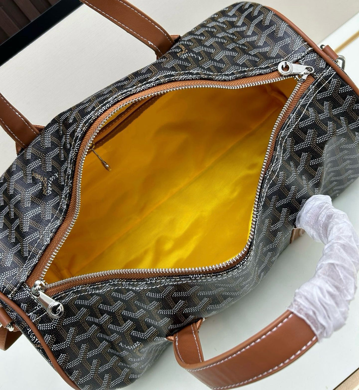 Open main compartment view of Goyard cylinder duffel bag showing bright yellow lining