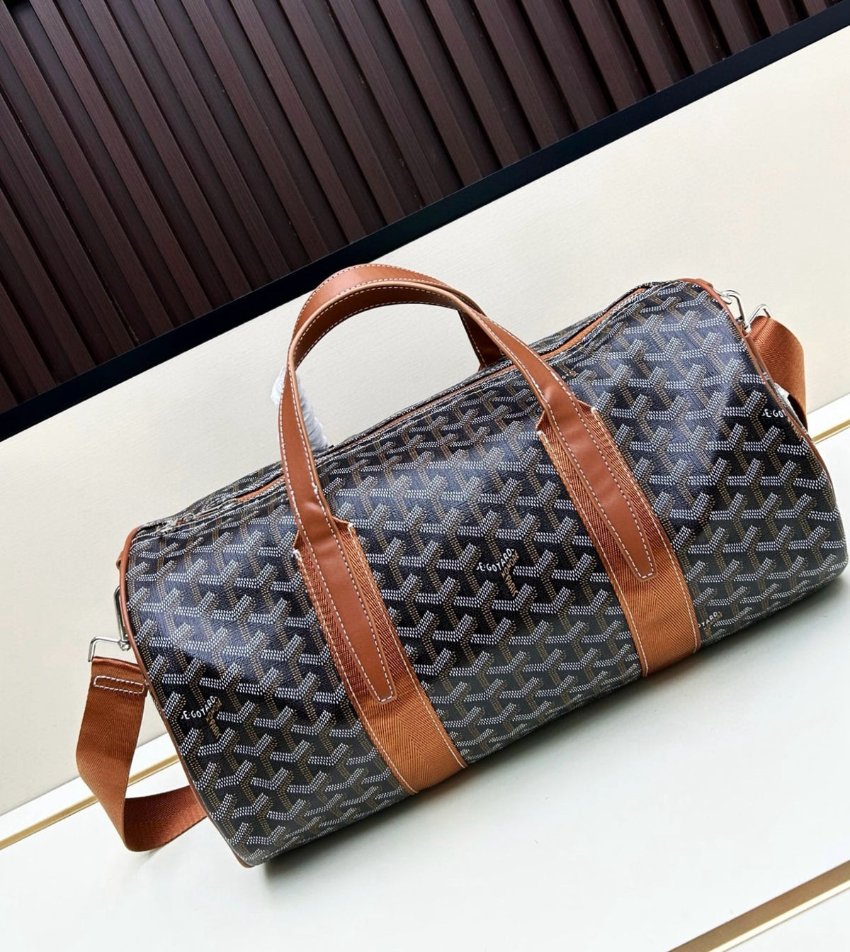 Black Goyardine canvas barrel bag with brown leather handles