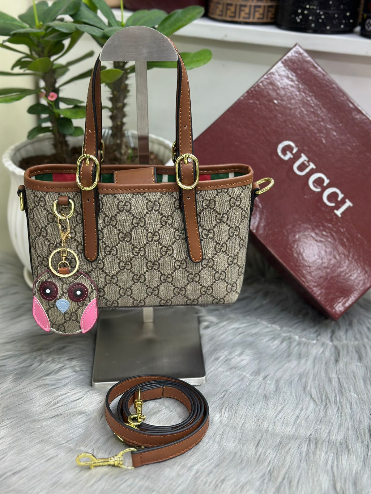 Gucci GG monogram canvas tote bag in brown with leather strap and decorative charm
