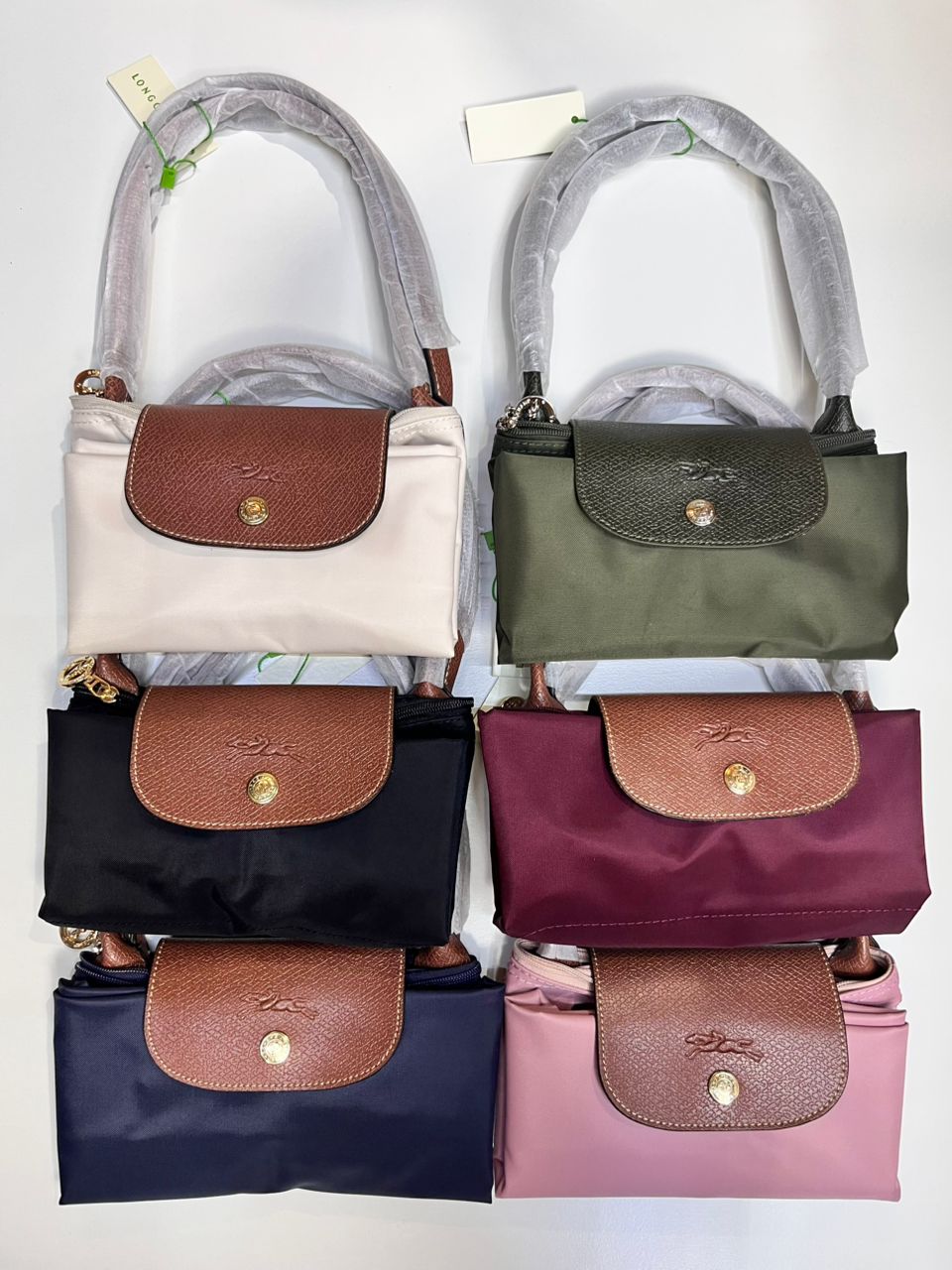 Longchamp foldable tote bags stacked in multiple colours