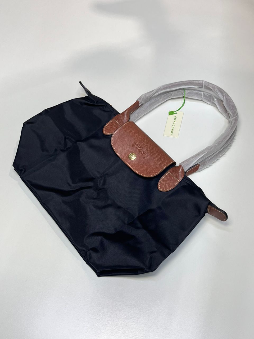 Navy Longchamp tote bag in compact folded form