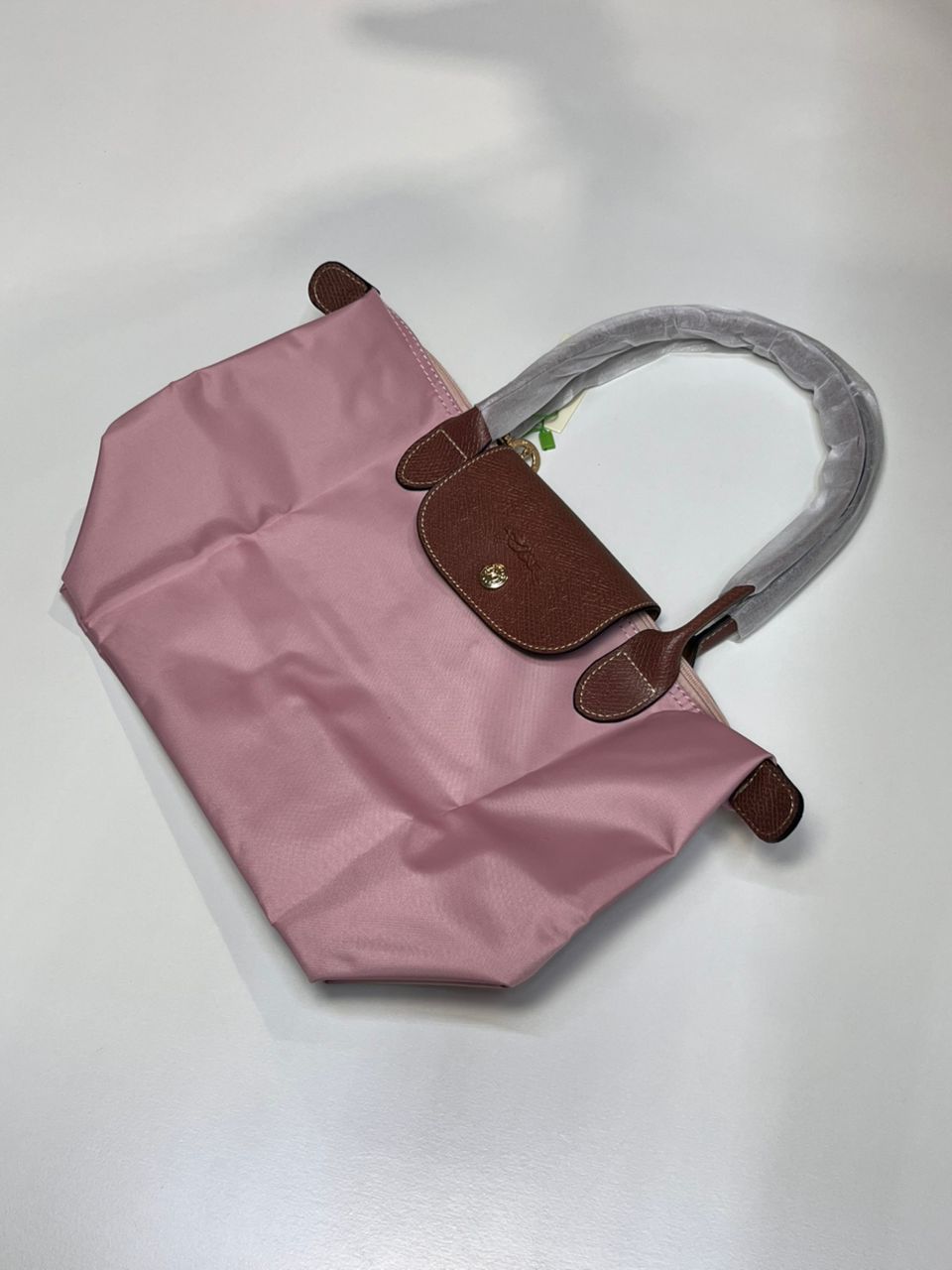 Pink Longchamp tote bag shown in folded form