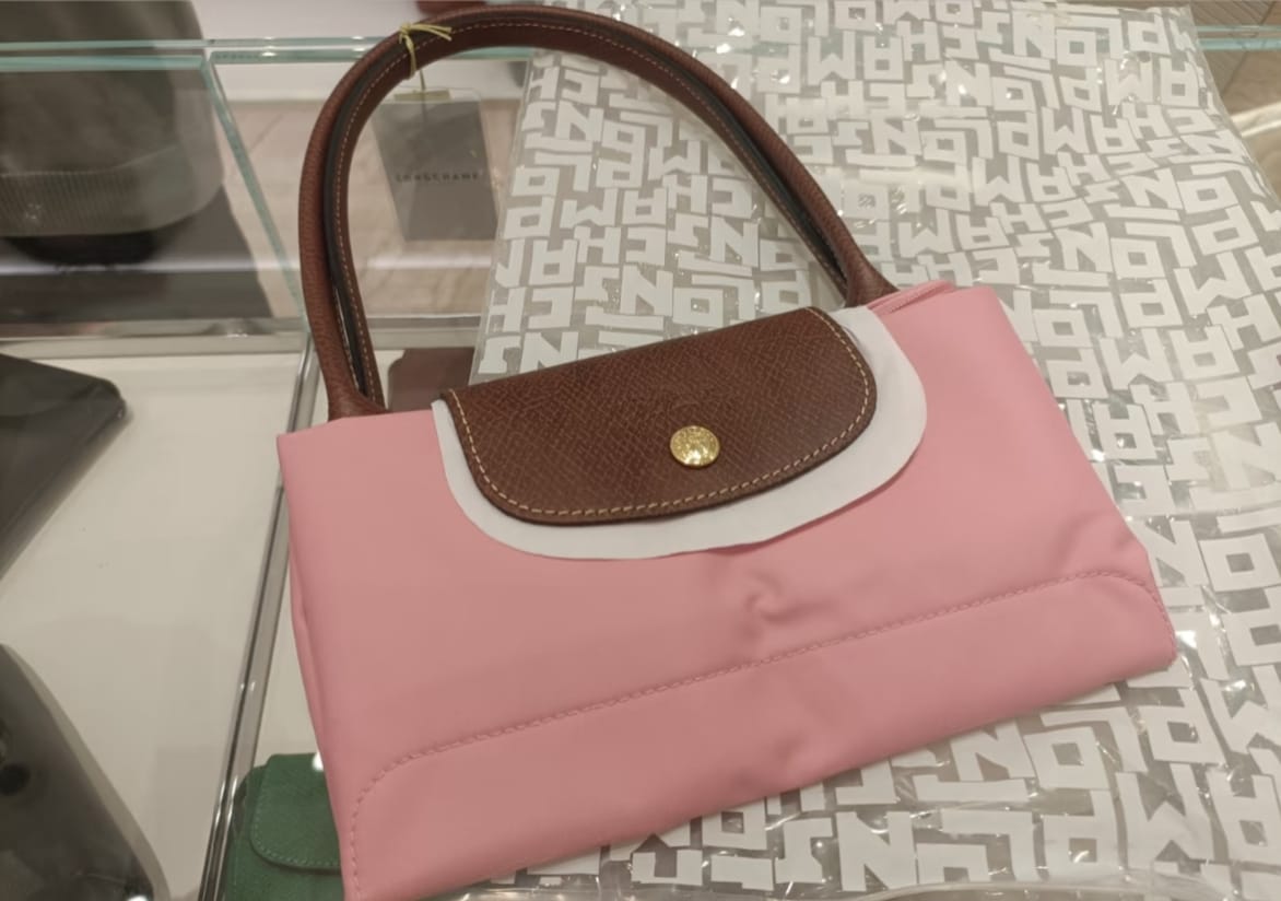 Pink Longchamp tote bag displayed in a lifestyle setting