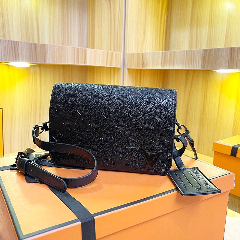Black embossed monogram crossbody bag with adjustable shoulder strap