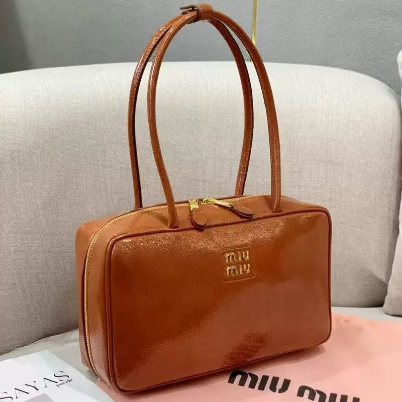 Cognac tan brown Miu Miu leather top handle bowling bag on display