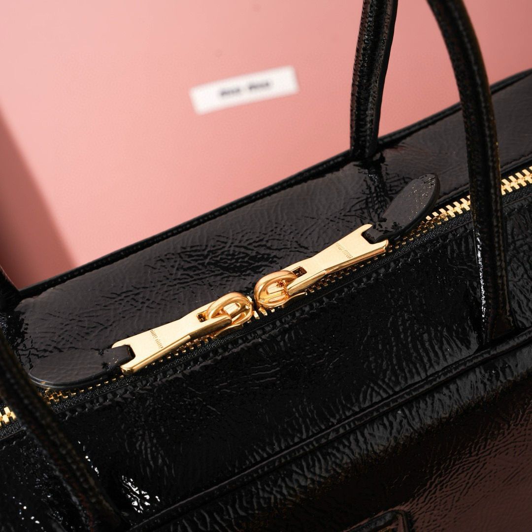 Close up view of top gold zipper hardware on Miu Miu leather bag
