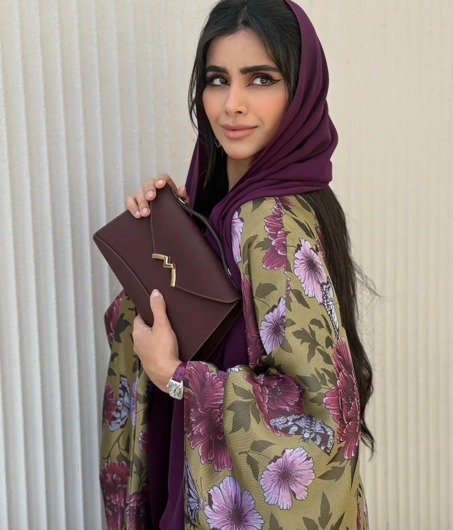 Woman carrying a burgundy Moynat Paris structured handbag
