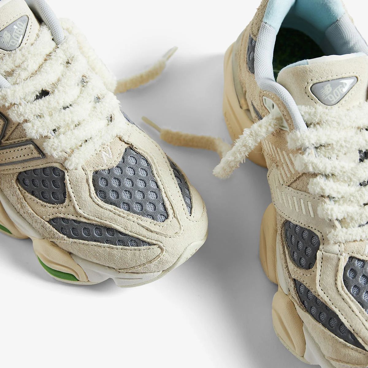 Close-up of cream and grey New Balance 9060 shoes