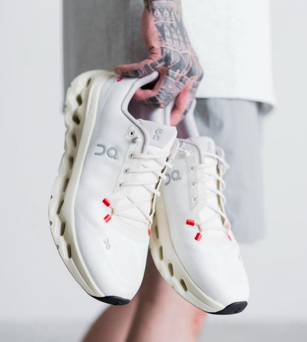 On Cloudtilt women’s White and Ivory shoes held in hand